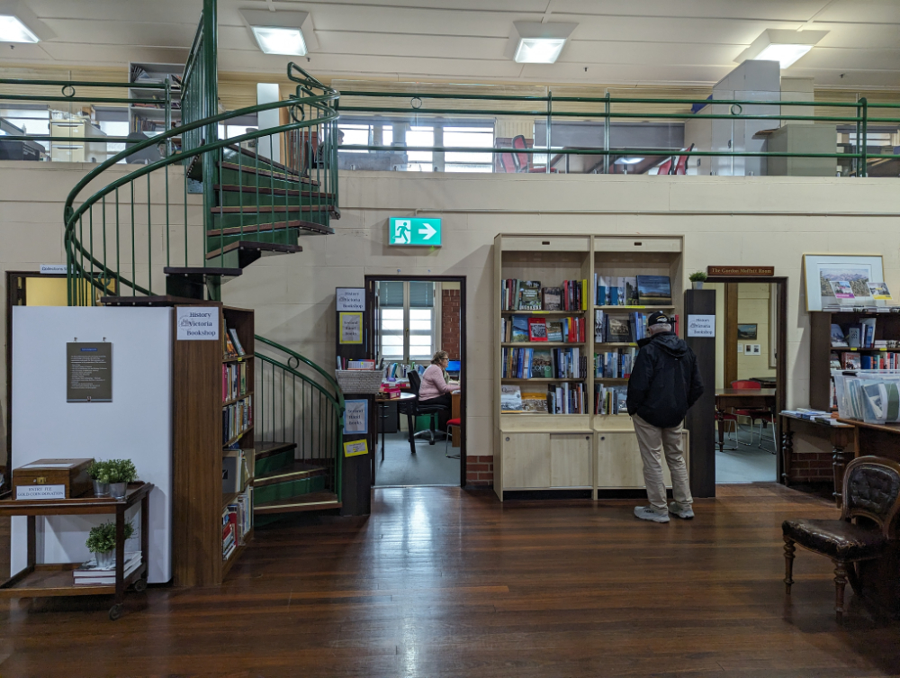 Standing at a bookshelf where they manage history