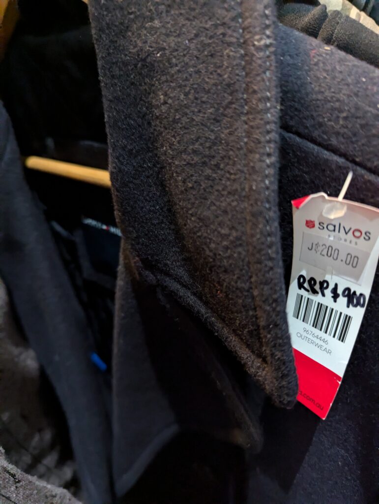 Dark jacket with thrift store price tag showing bargain