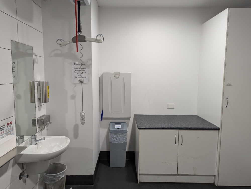 Accessible bathroom showing an adult change table with a ceiling hoist