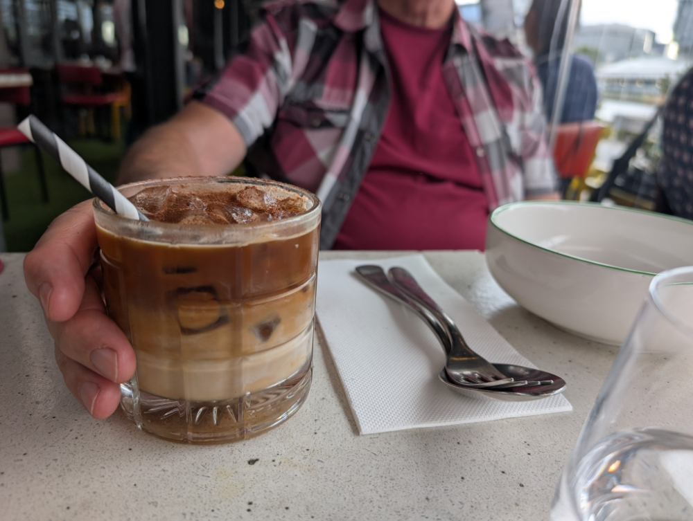 Close-up of hand holding an iced coffee